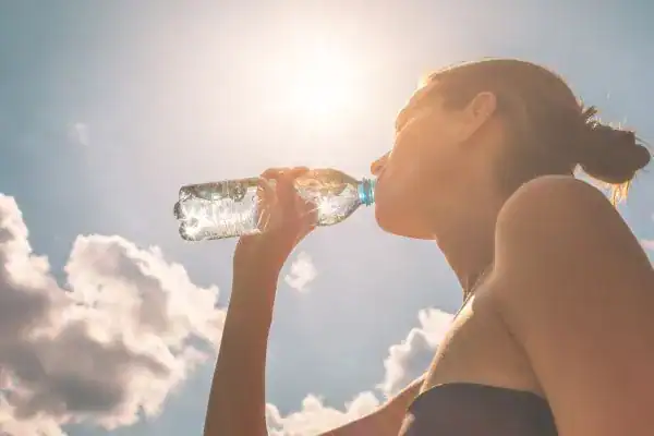 Hydration: The Secret Ingredient for a Toned Stomach and Enhanced Fitness 3 Image of woman drinking water to hydrate West Mersea after run.