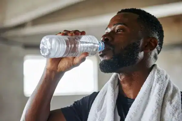 Hydration: The Secret Ingredient for a Toned Stomach and Enhanced Fitness 1 Image of man drinking water to improve hydration West Mersea after work out.
